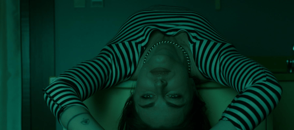 A woman lies on her back, arms overhead.